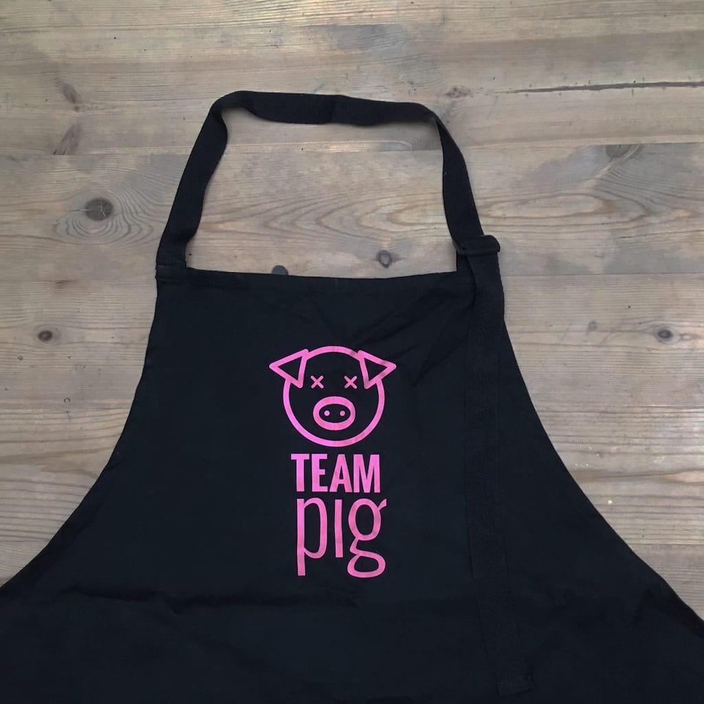 Pink Team pig branding on black apron